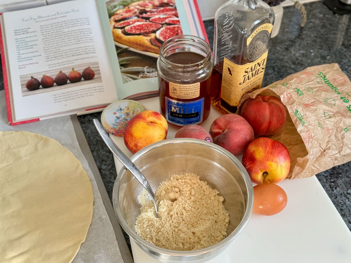 ingredients for an easy peach tart with puff pastry, almond flour, peaches, honey and rum