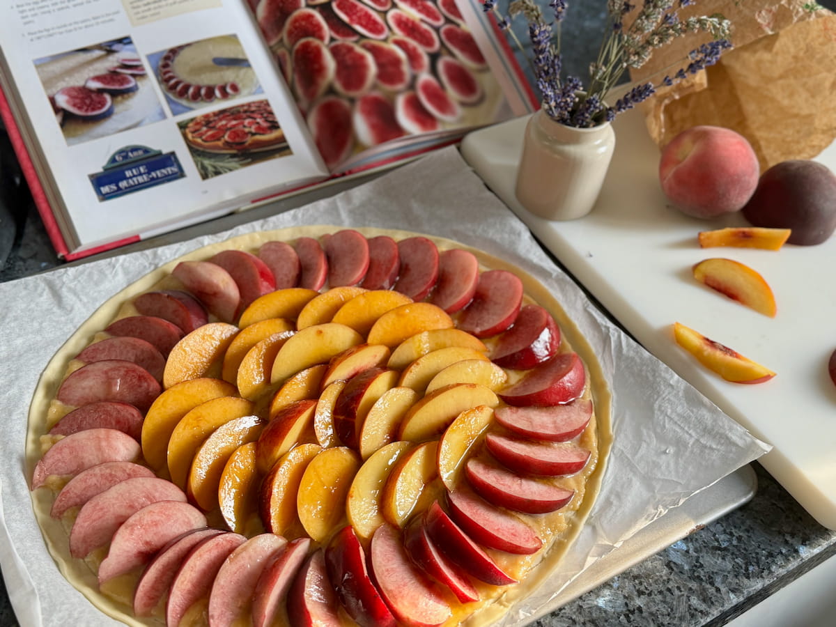 Following a French pastry recipe book making a tart with fresh peaches