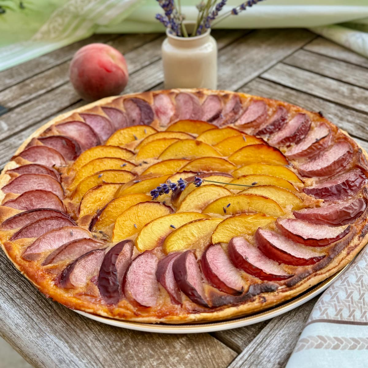 fresh peach and nectarine slices arranged on puff pastry and an almond paste