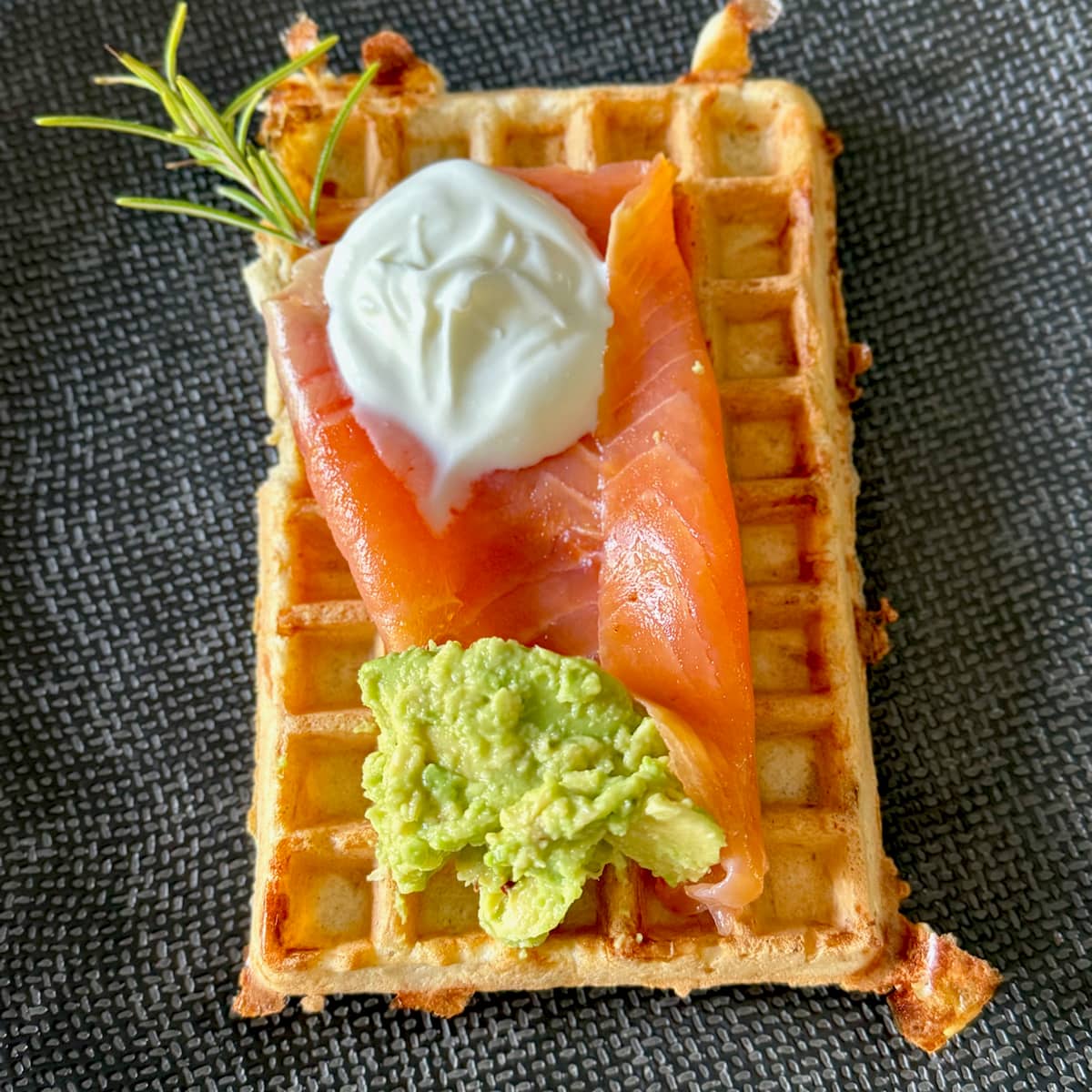 savoury waffles topped with smoked salmon, smashed avocado and soured cream