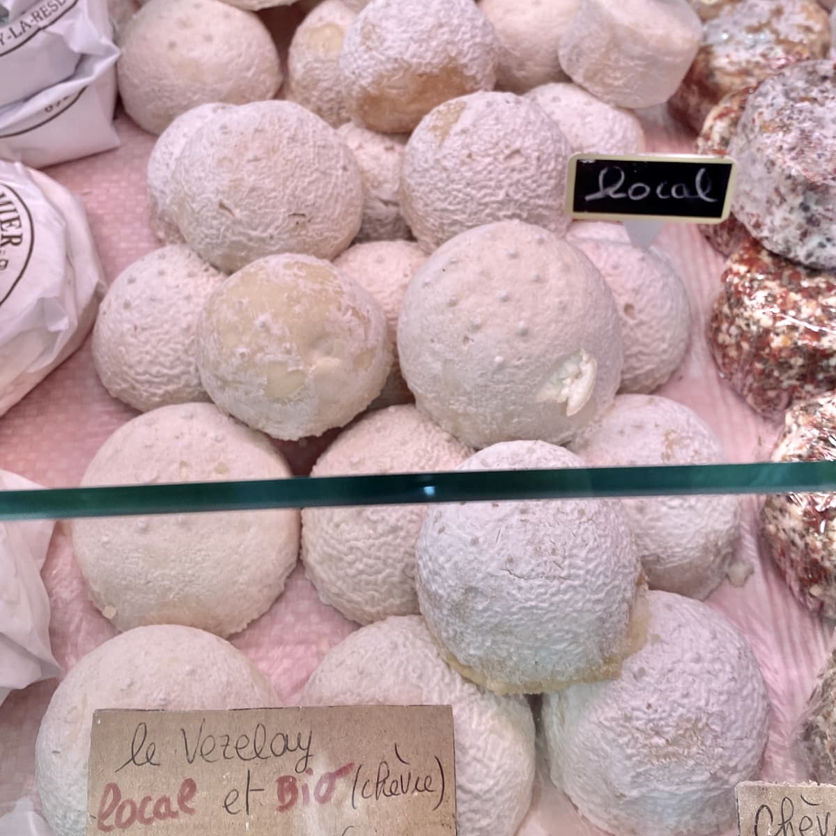 pile of semi sphere goat cheeses in a French cheese shop