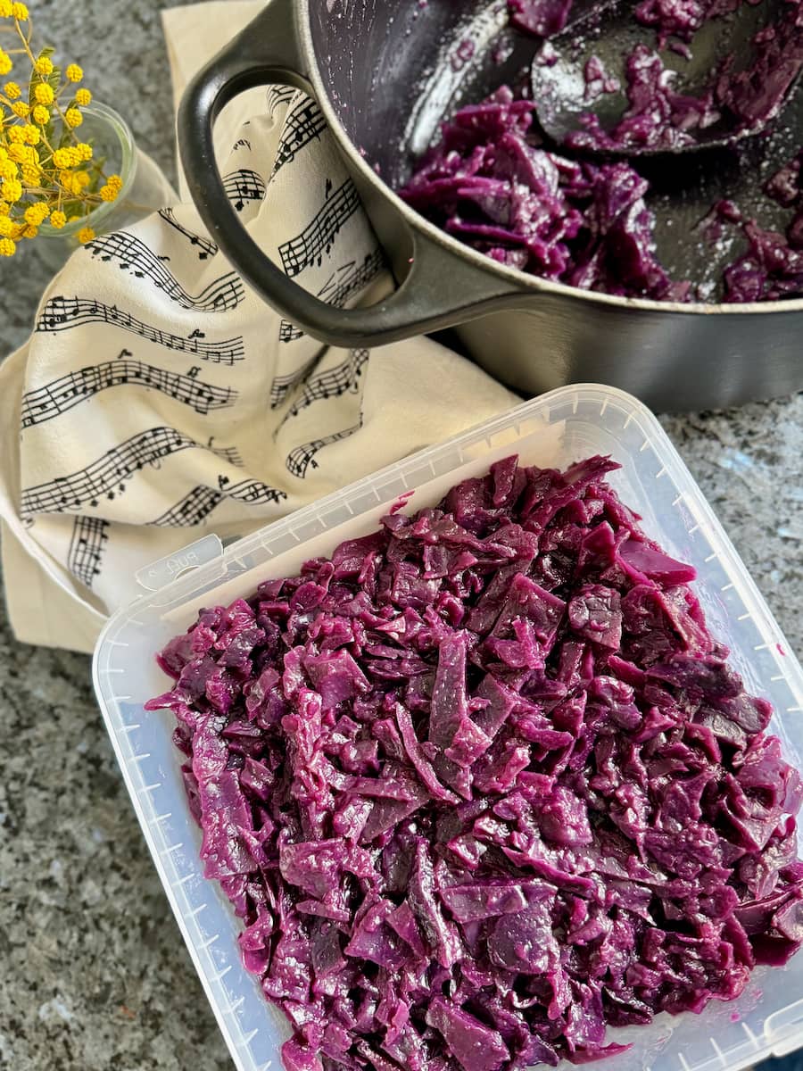 spooning leftover cooked red cabbage into a freezer container