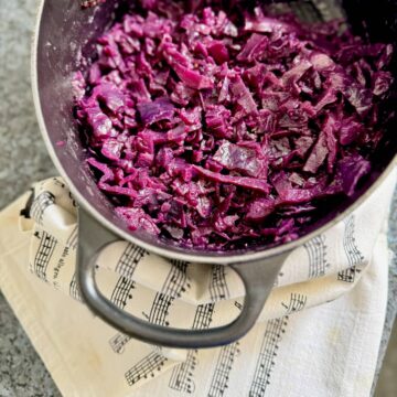 cooking pot with vibrant red cabbage cooked in vinegar, apple, onion and spices