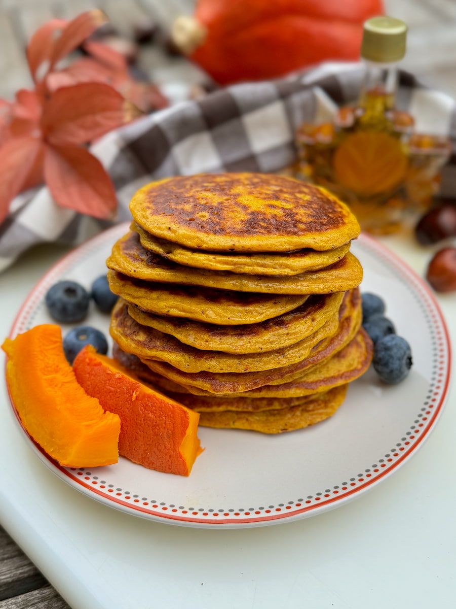 pile of pancakes made with cottage cheese and eggs, served on a plate with blueberries