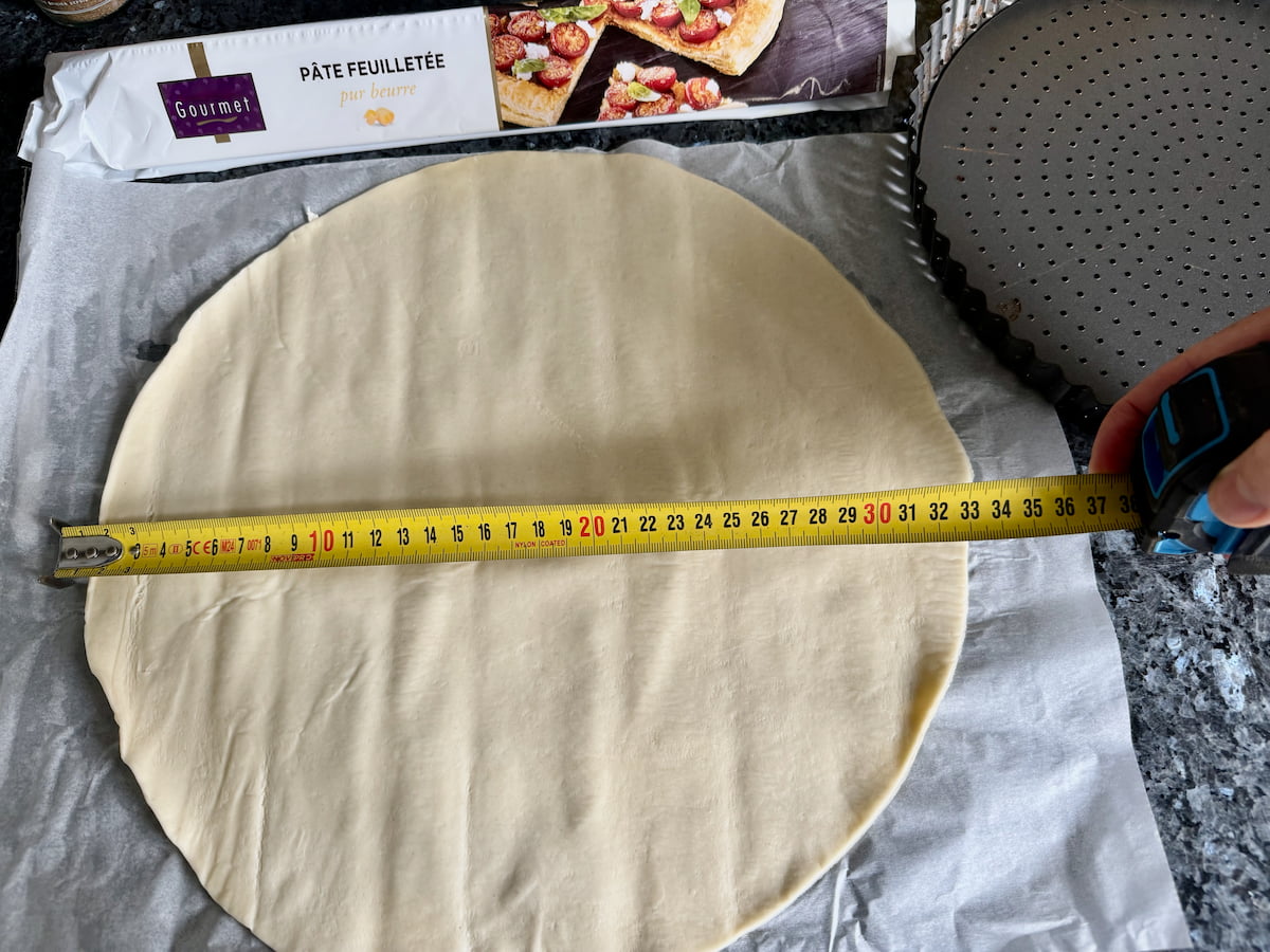 round flat sheet of puff pastry with a tape measure showing 32cm diameter next to French packaging