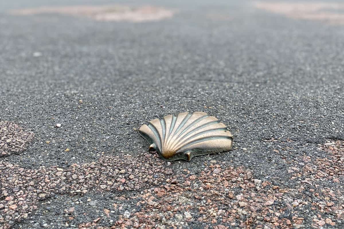 a bronze scallop shell stuck to the road in Vezelay, France