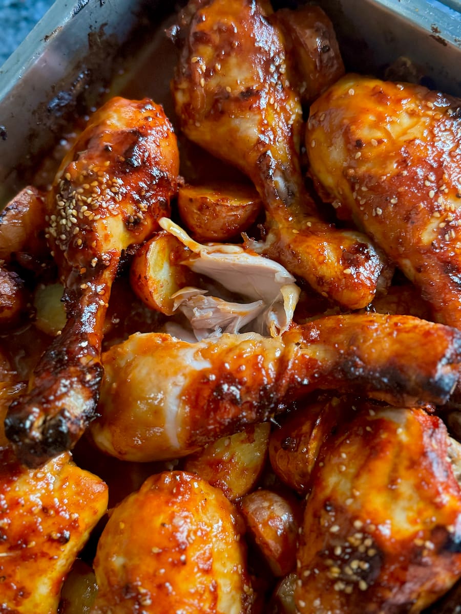 roasted chicken drumsticks covered in a shiny barbecue sauce, falling apart as the meat is so tender