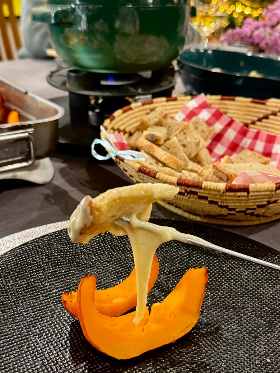 melted cheese on bread on a skewer, melting over two slices of roasted pumpkin