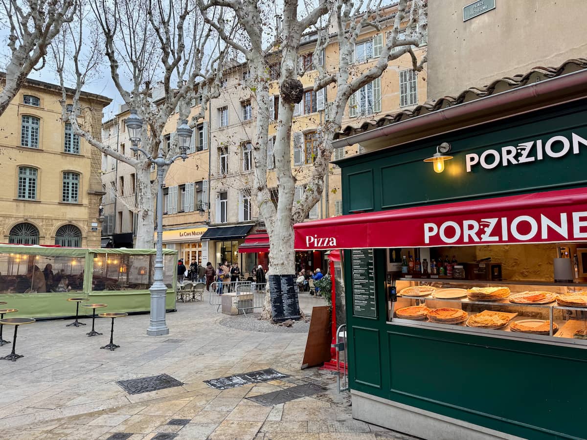 large square in Aix during winter with plane trees and a welcoming pizza stand