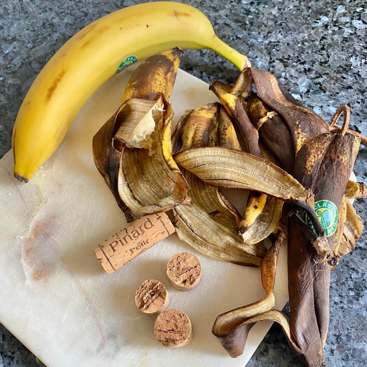 ripe brown banana skins attracting fruit flies next to wine corks