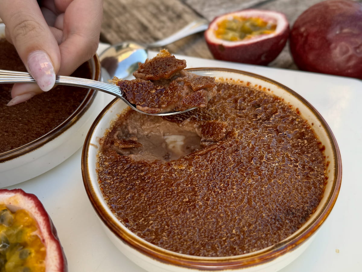cracking into a chocolate creme brulee next to passion fruit