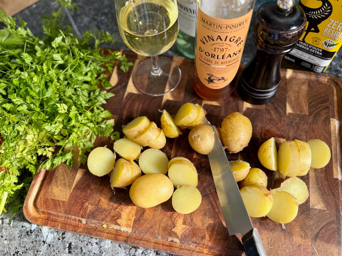 Slicing potatoes while cooled to warm to make a French potato salad